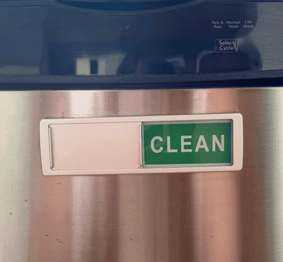 A person toggling between &quot;dirty&quot; and &quot;clean&quot; on a magnet on a dishwasher