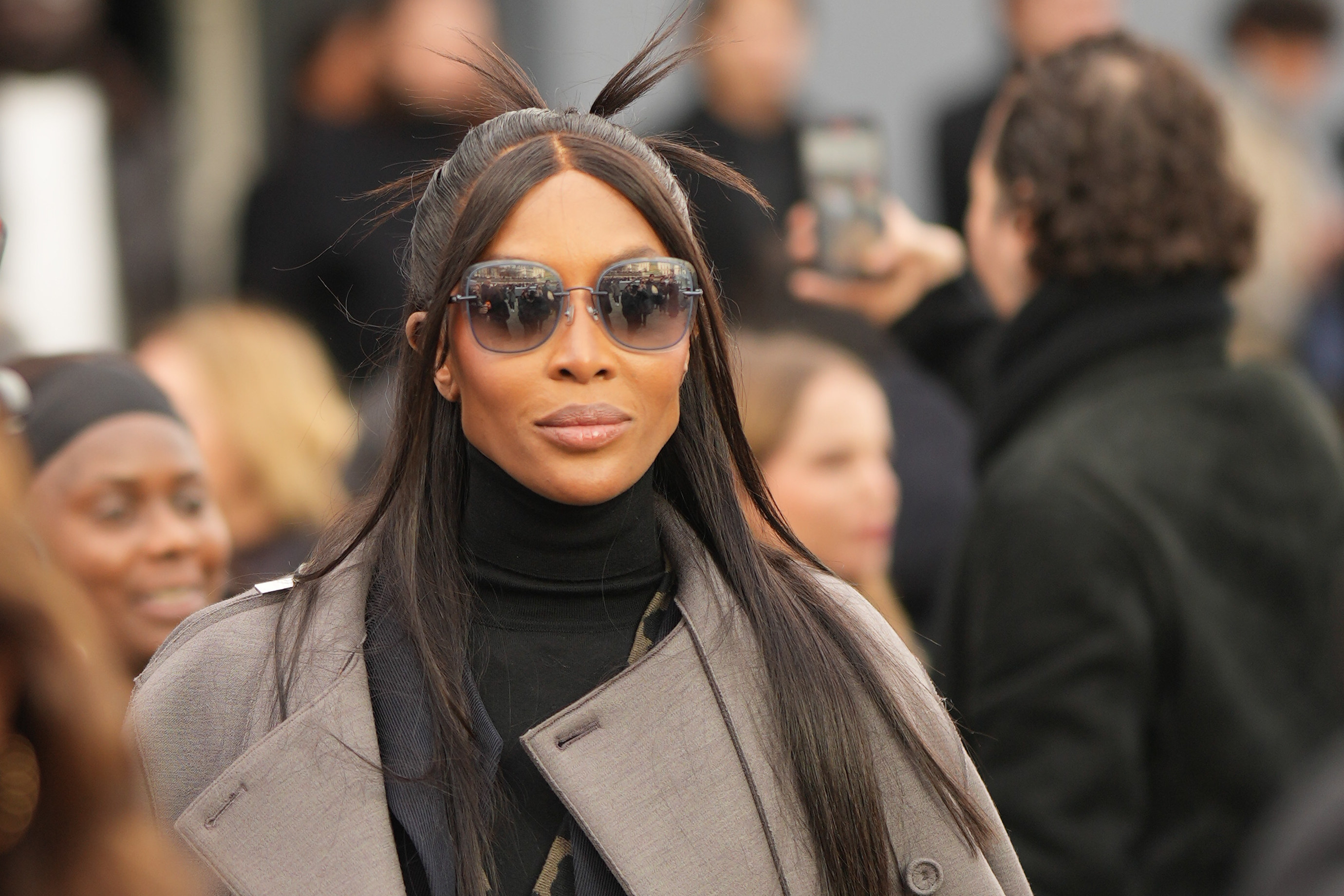 naomi campbell in a black turtleneck, gray coat, and sunglasses