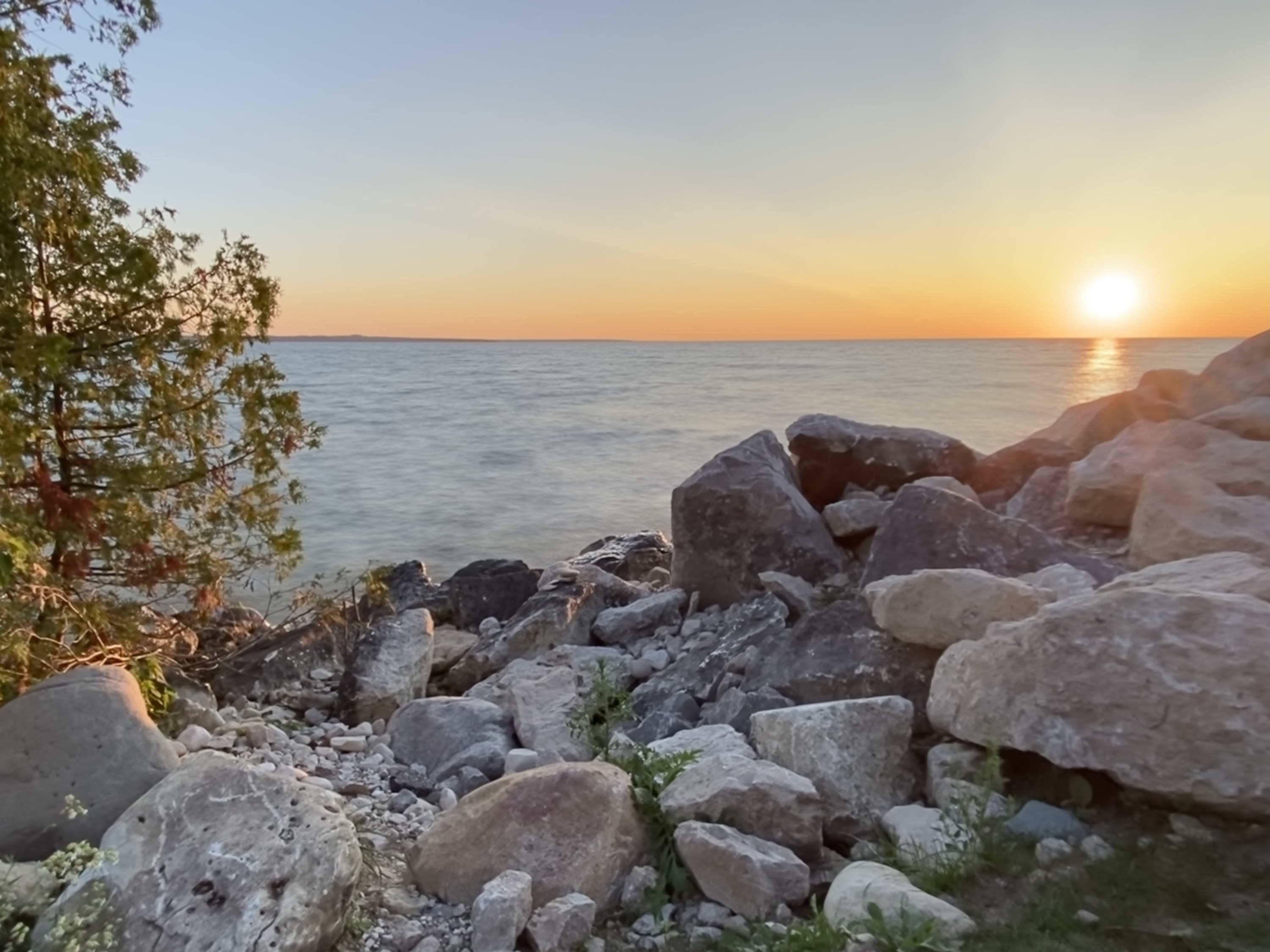 rocks on the shore in the upper peninsula of michigan at sunset