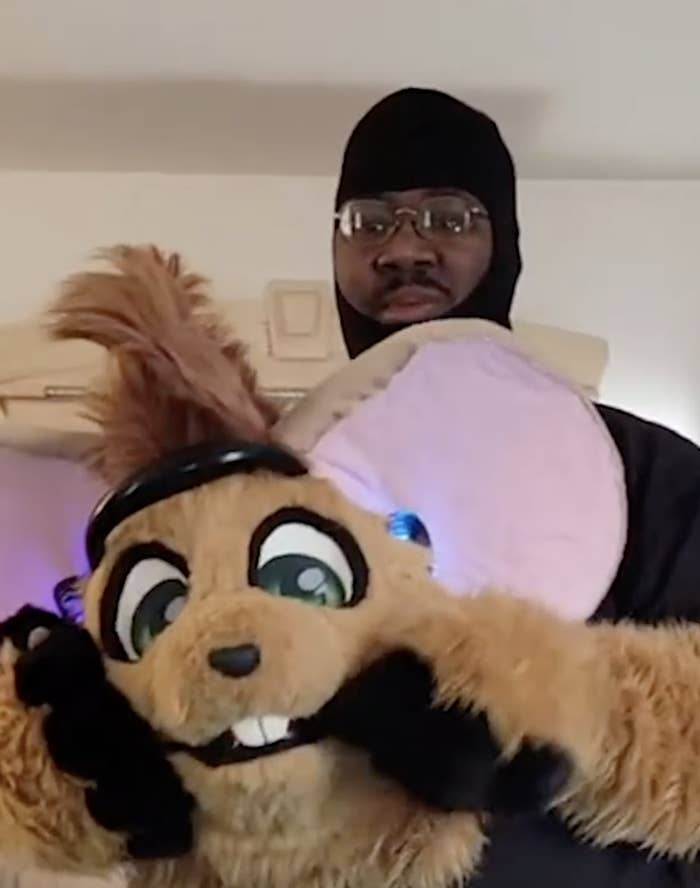 Lamar holding the head of his Furry costume Gibson the Mouse