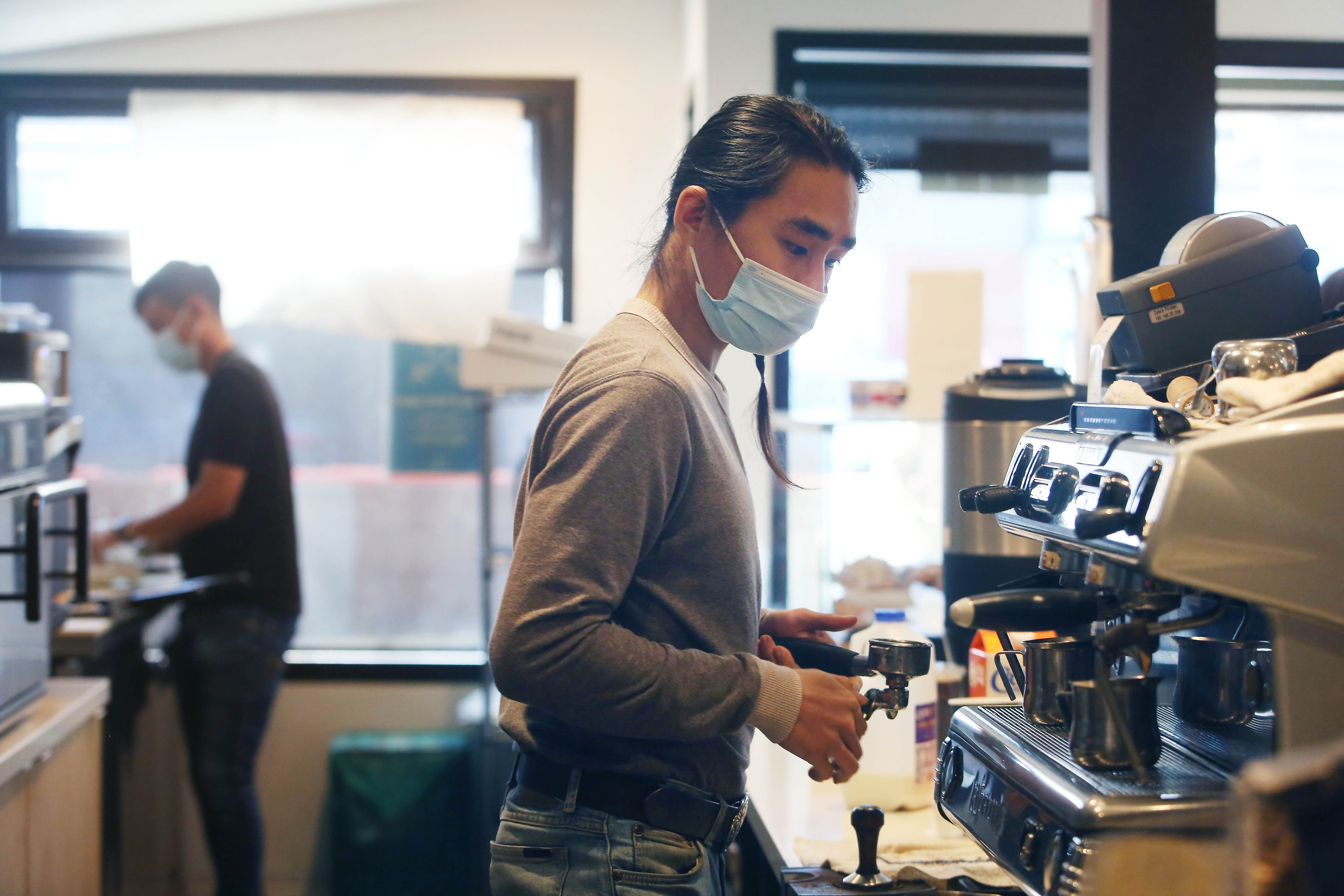 Baristas wearing surgical masks and making drinks