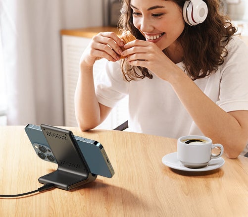 A person using the charger with their phone in landscape mode