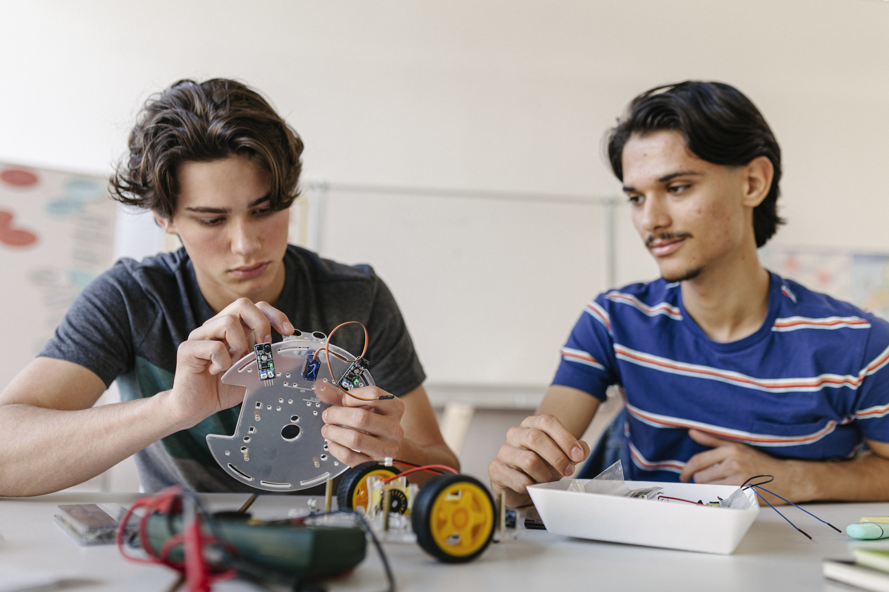 two teenage boys working on a robotic project in a german high school