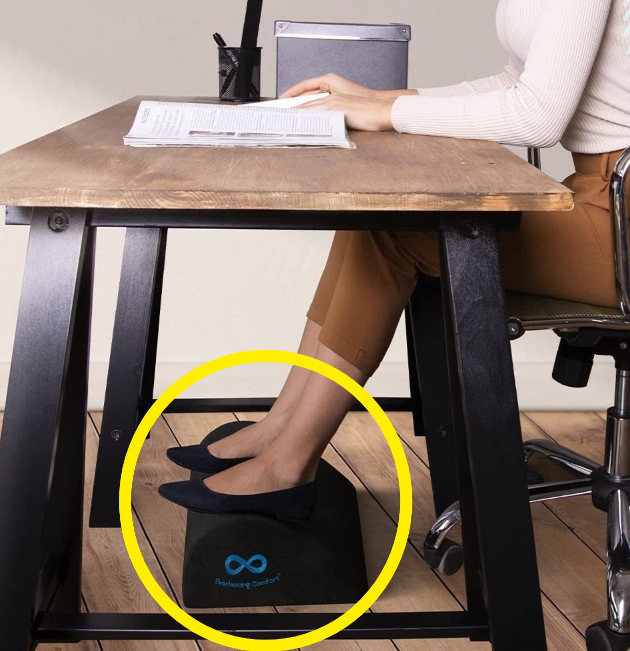 A person sitting at an office desk with their feet rested on the cushion