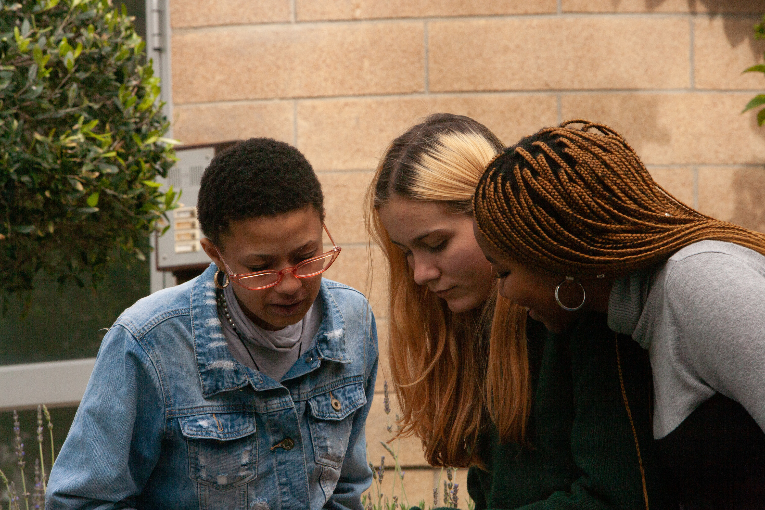 three women leaning in to see something