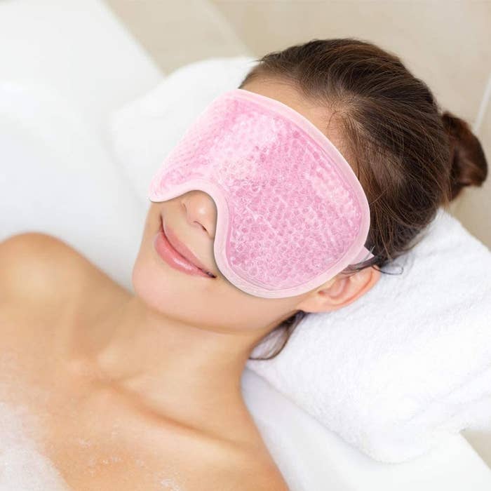 a person lying in a tub wearing the eye mask