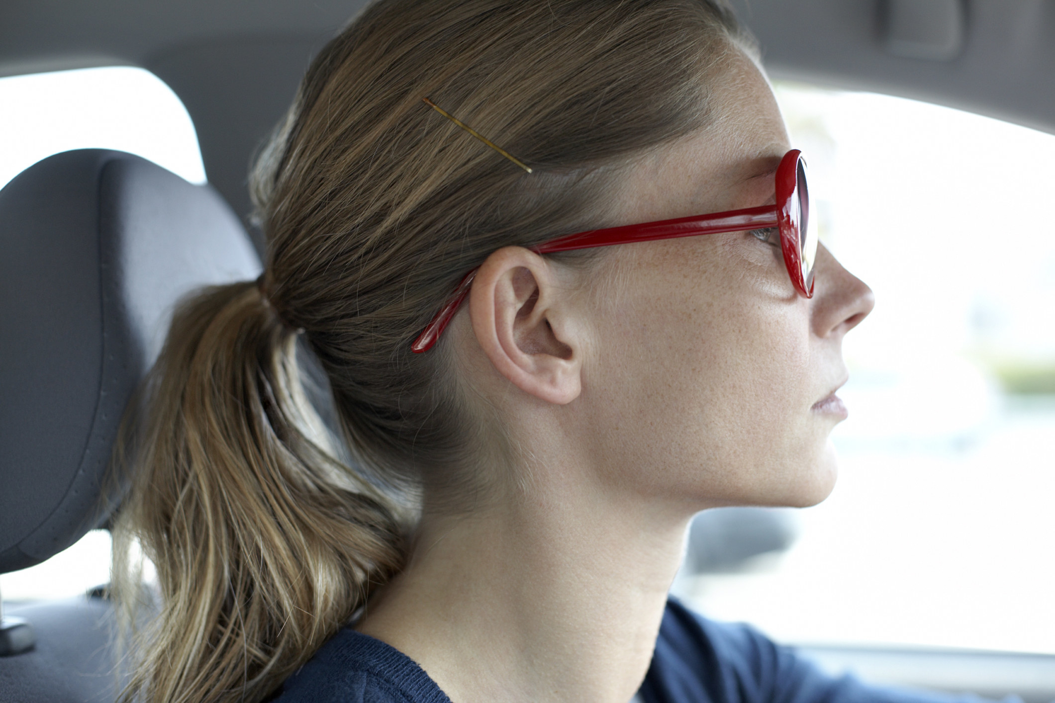 A woman with a ponytail in a car