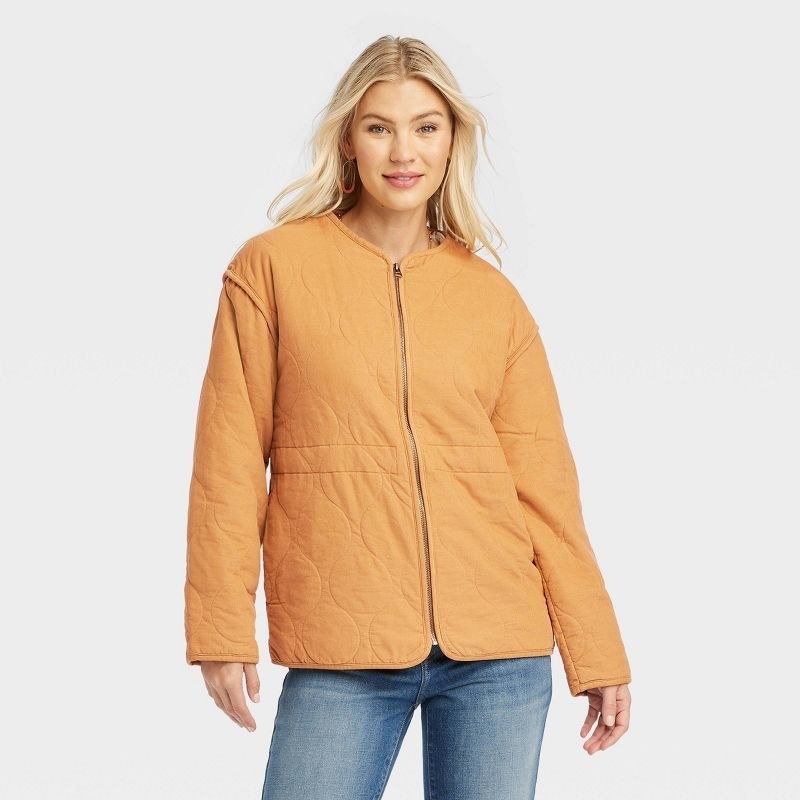 Model wearing orange coat with jeans