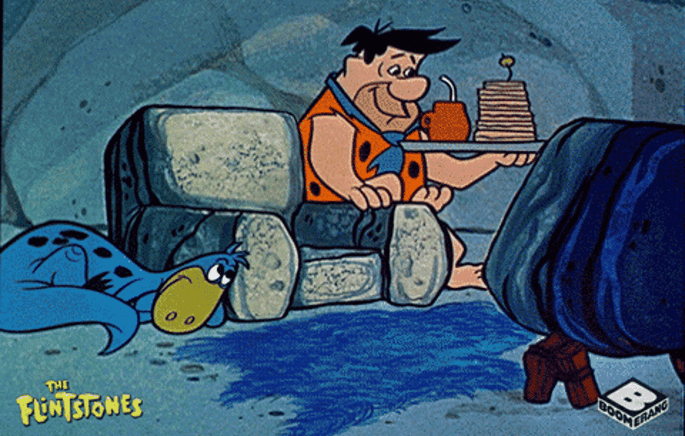 Fred flintstone turning on the TV sitting down to watch it