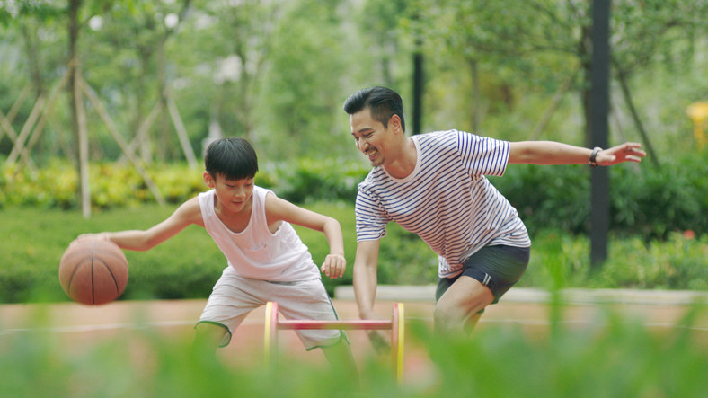 A father playing basketball with his son