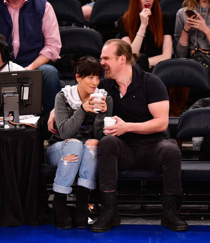 The couple sitting court side at a basketball game