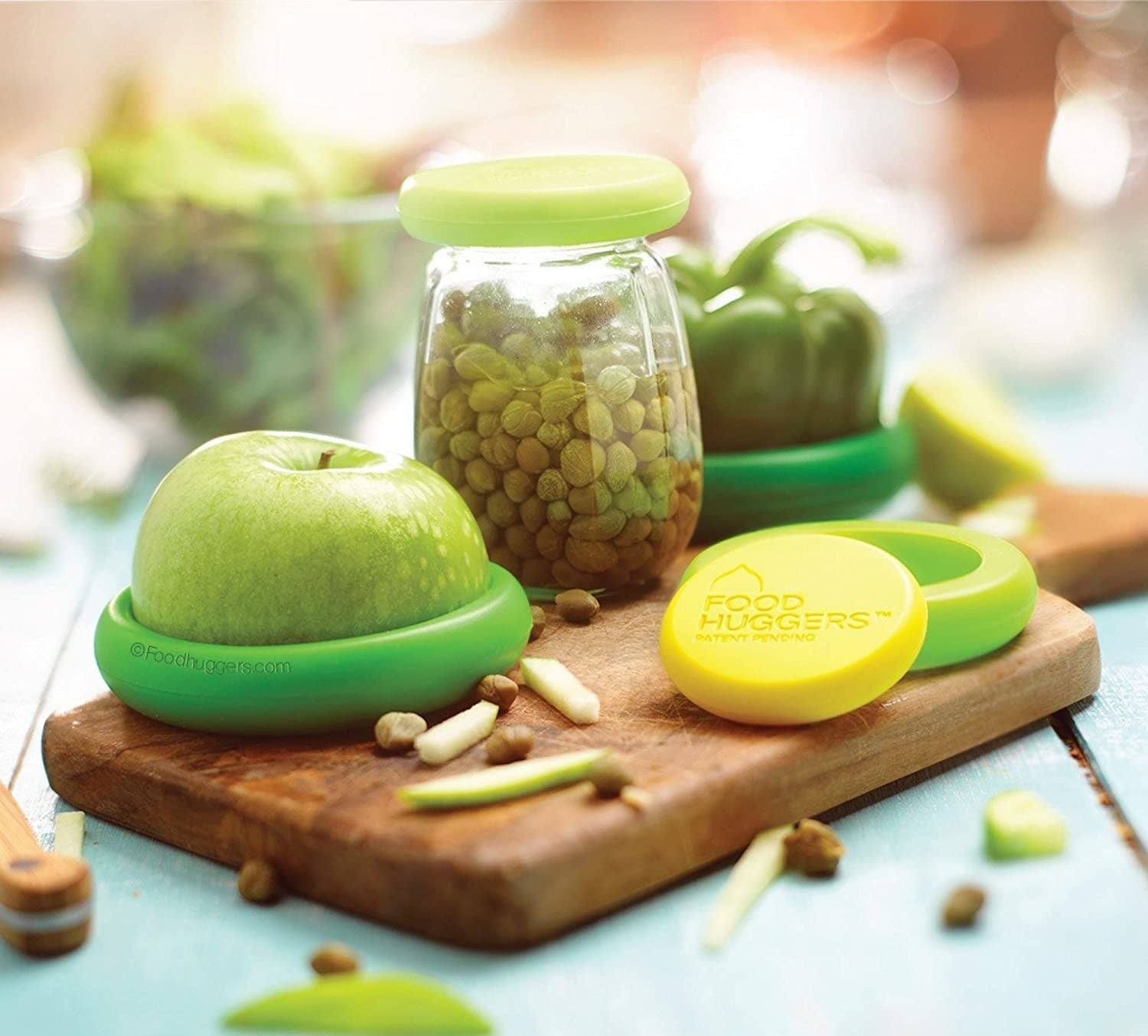 the food huggers snapped onto a jar of capers, half an apple, and a bell pepper