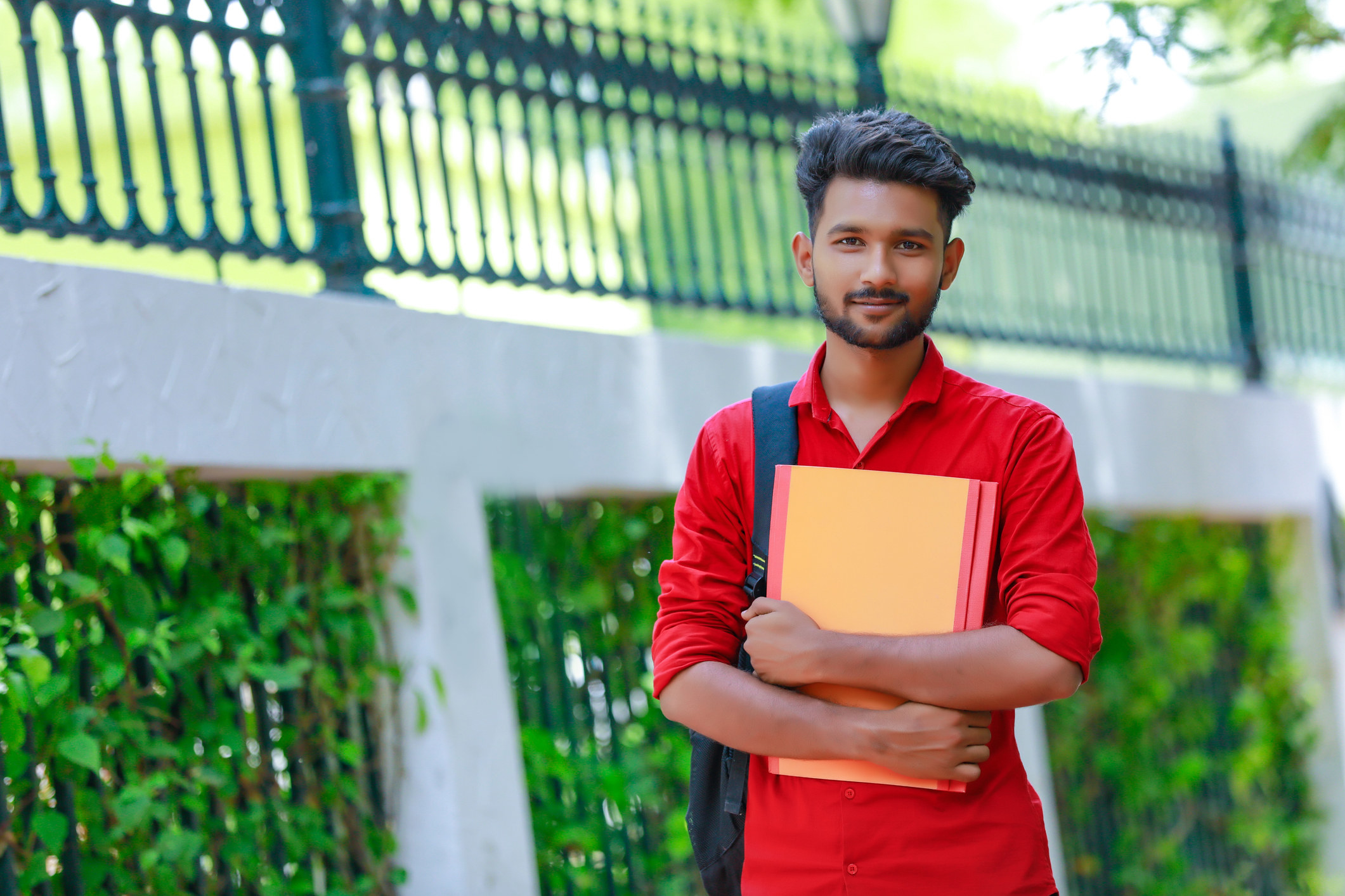 Asian student holding a book and carrying a backpack