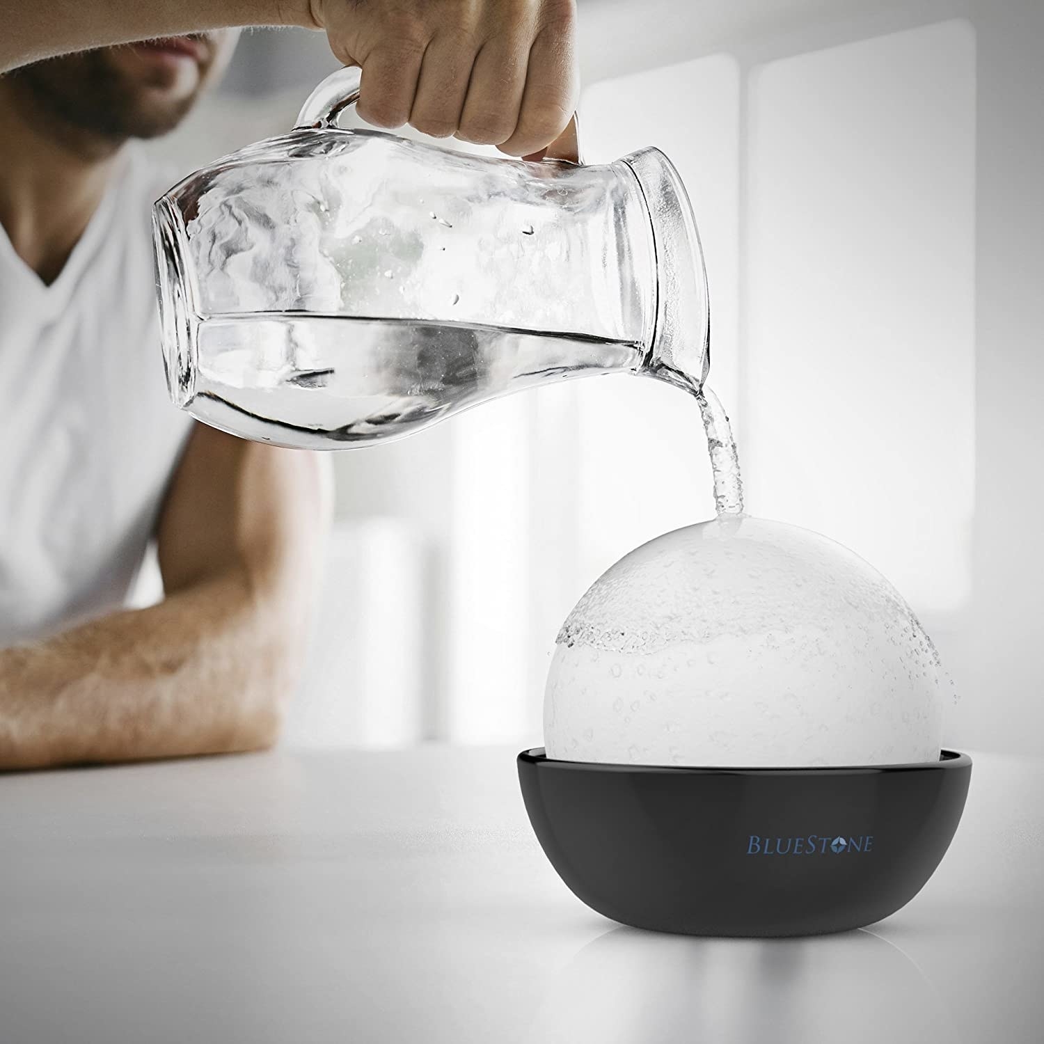 someone pouring water over the stone on the humidifier
