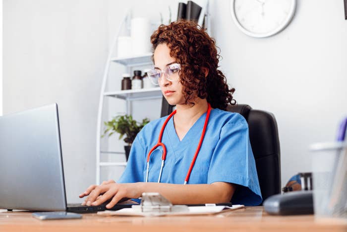 a female doctor typing on a computer