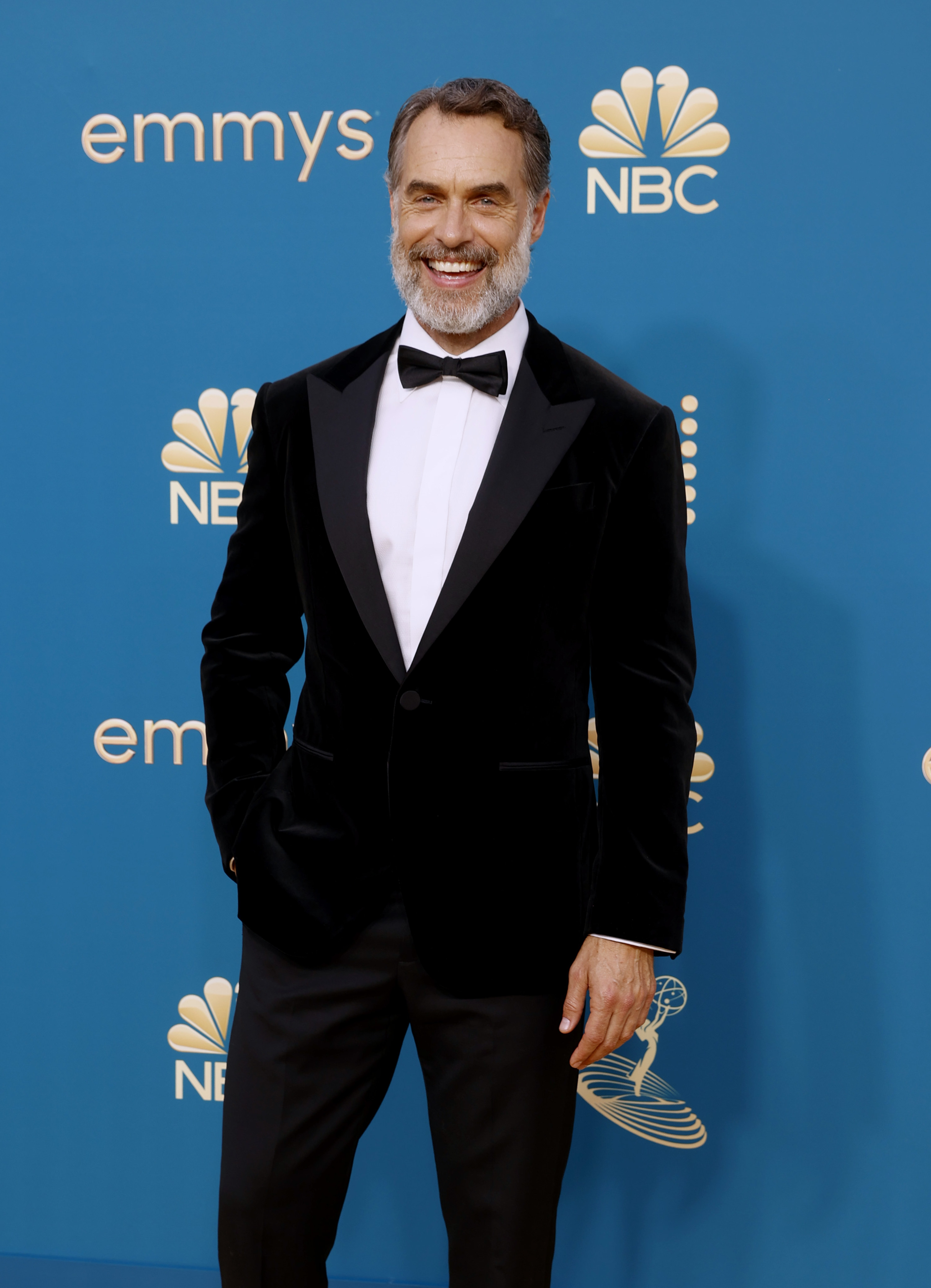 Murray smiles widely as he poses for photographers on the Emmys red carpet. Murray is wearing a tuxedo