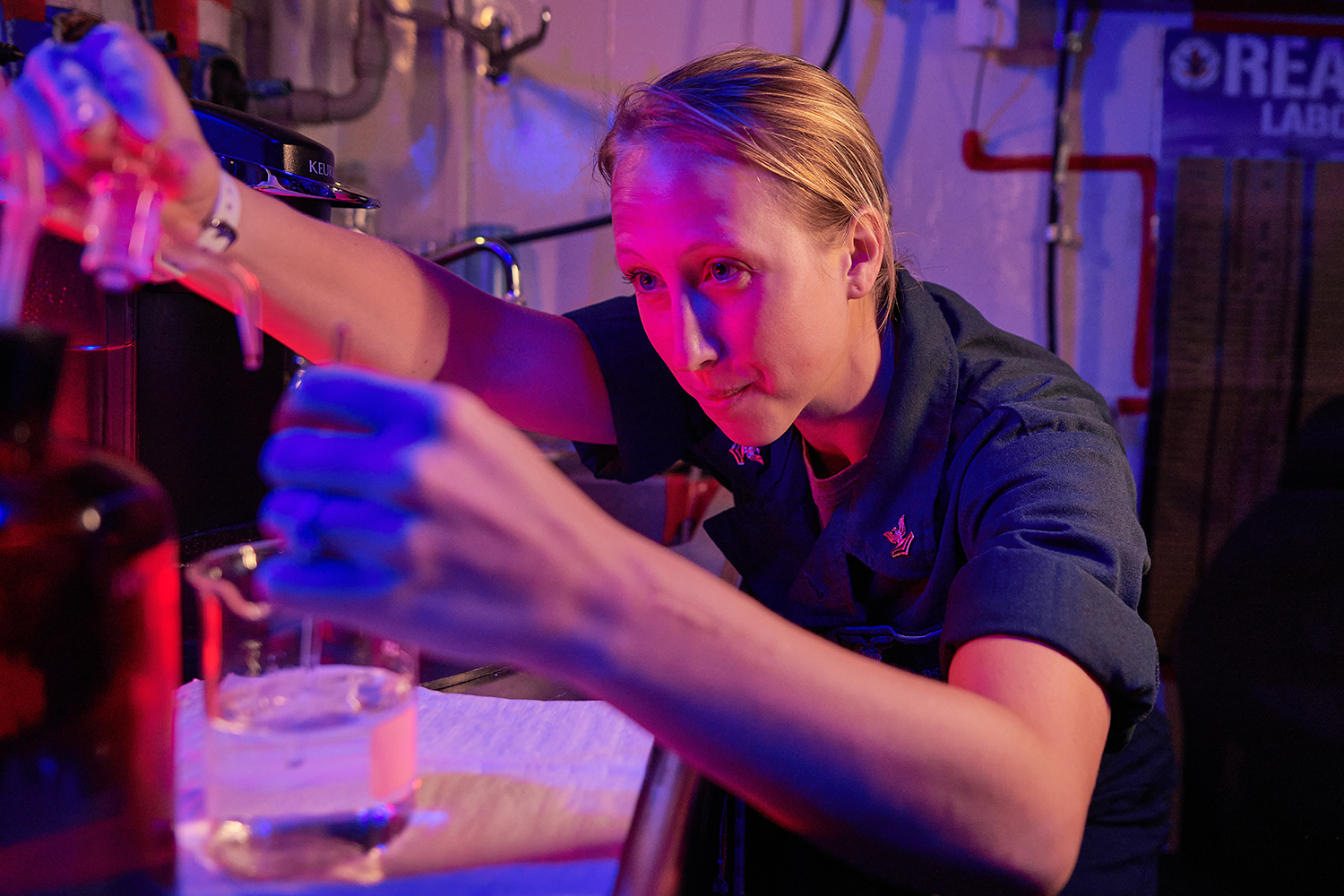 a person mixing substances in a beaker