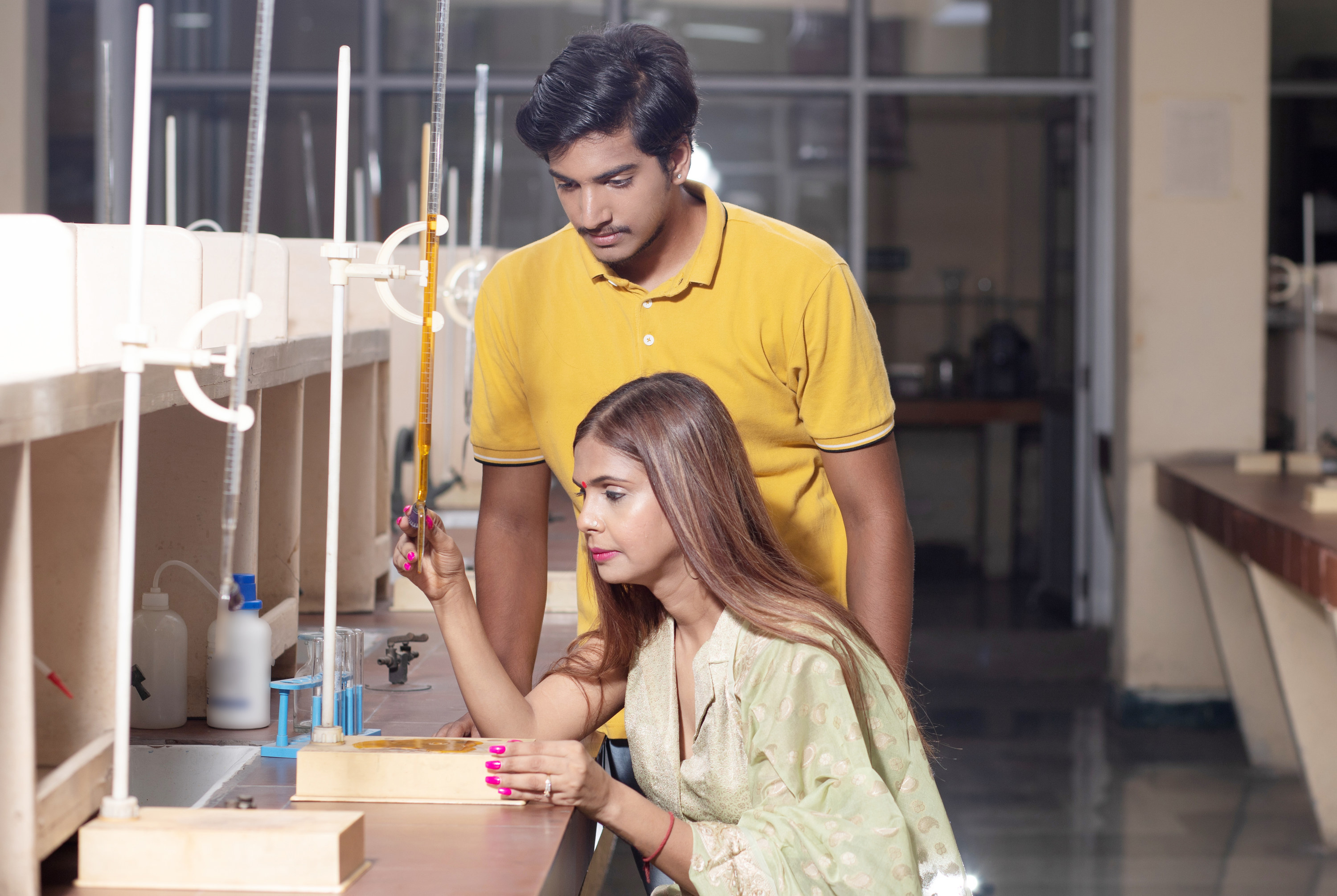 Indian student and teacher working together with science equipment