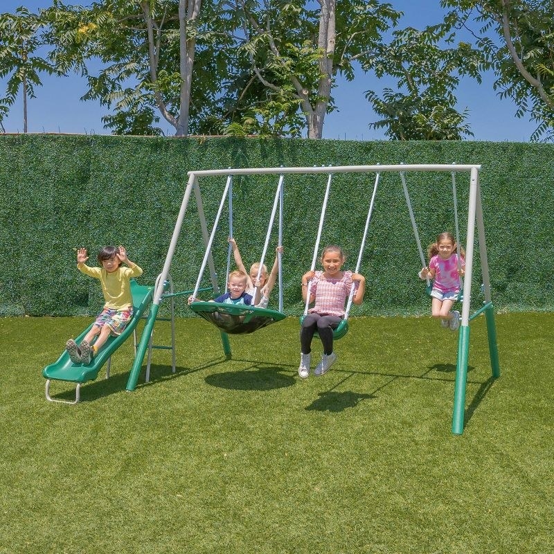 Kids playing on swing set on the grass