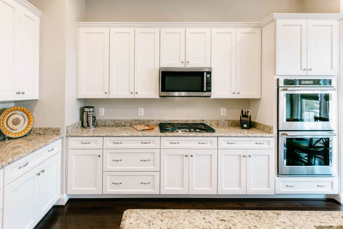 white kitchen with granite countertops and stainless appliances