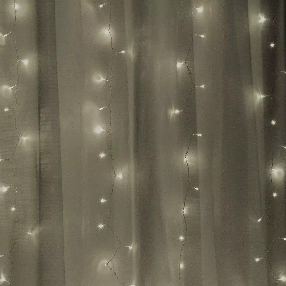 A picture of the sheer white curtains with the string lights
