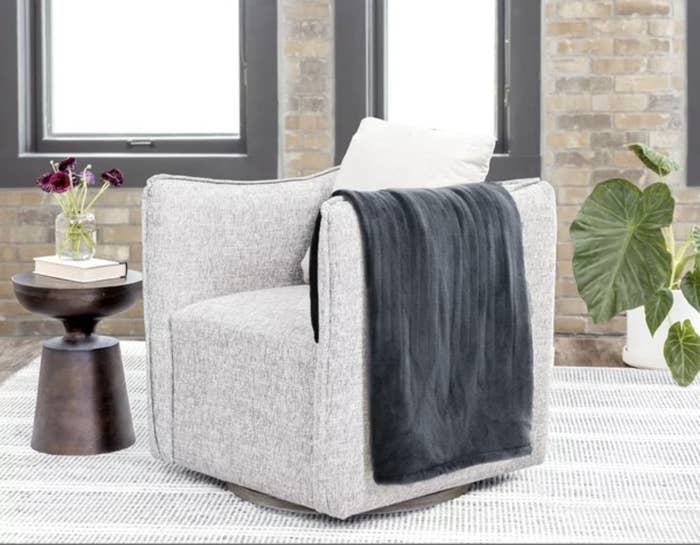 A gray blanket on a white chair