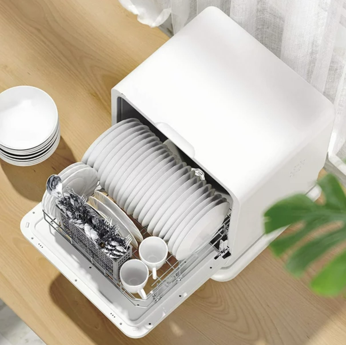 A white mini tabletop dishwasher