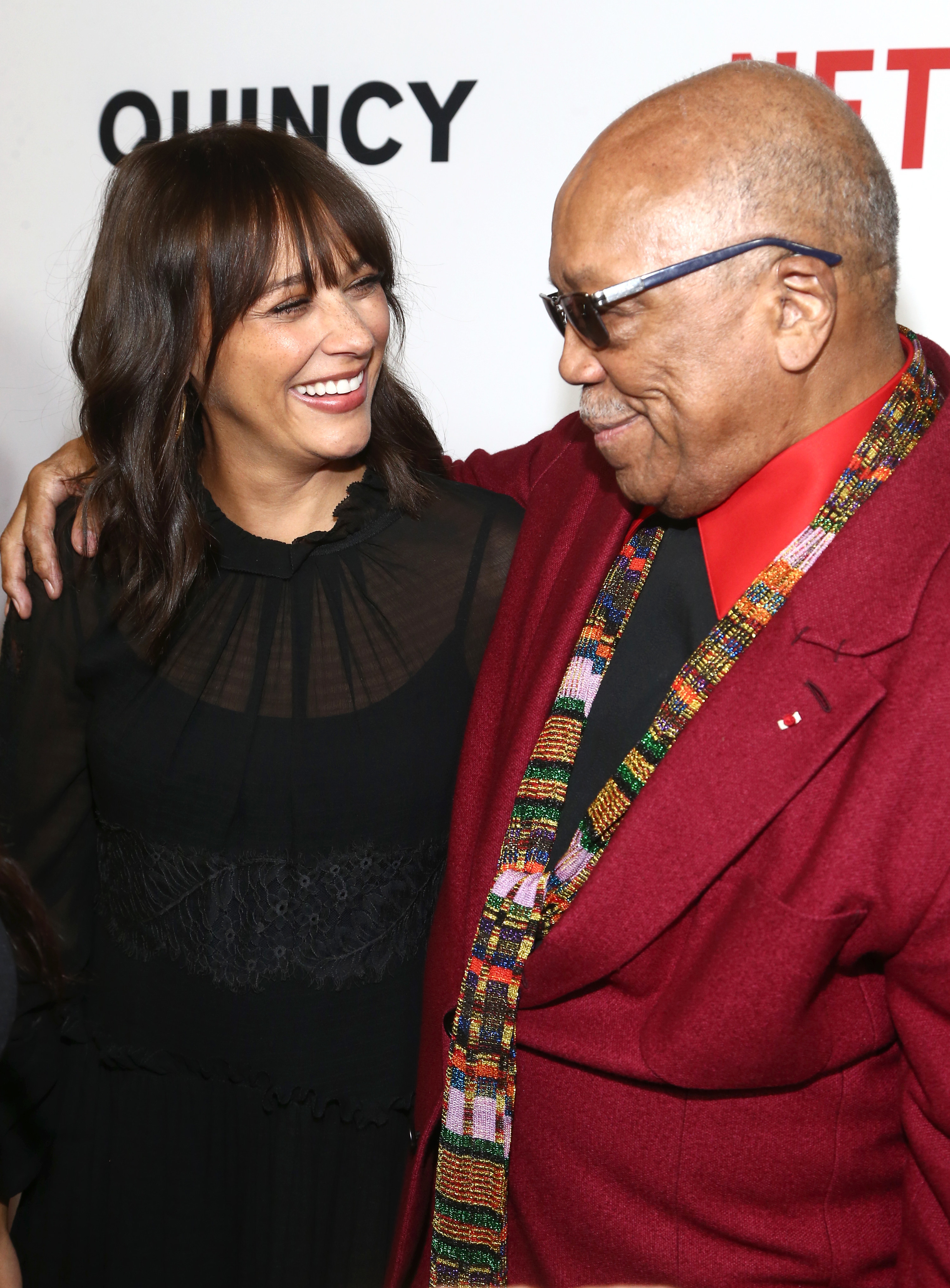 Rashida Jones and Quincy Jones smiling at each other