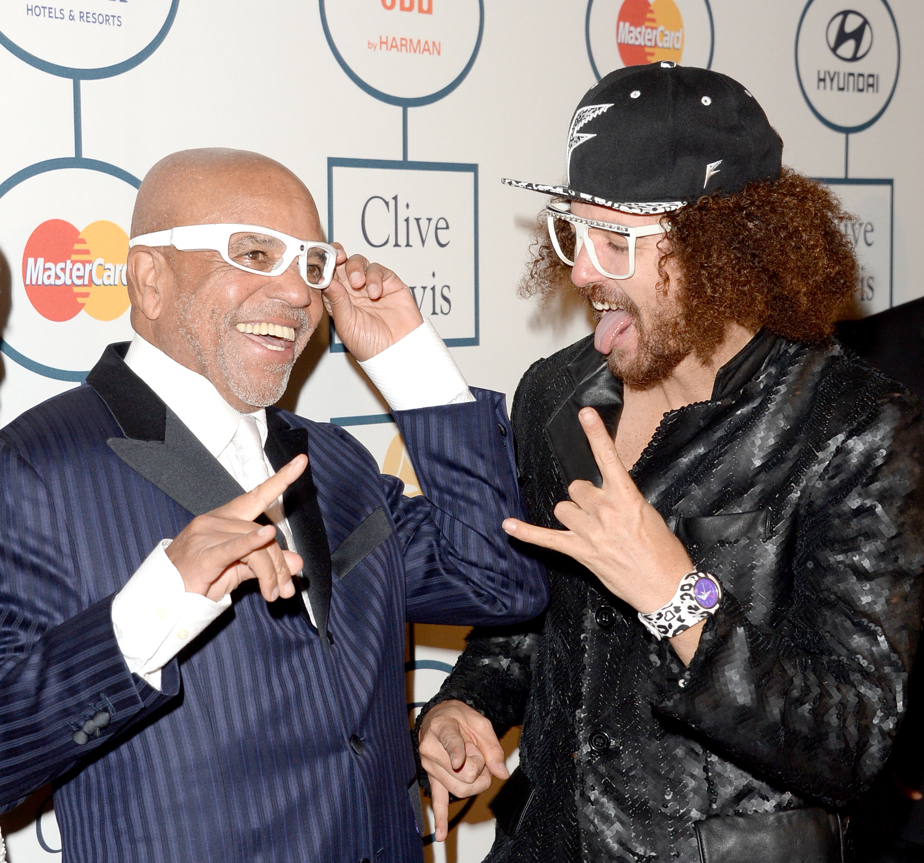 Redfoo and Berry Gordy Jr. smiling and giving hand gestures