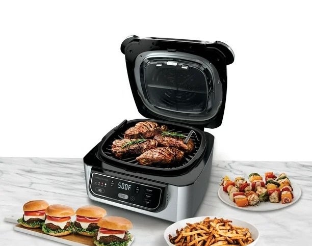 a silver and black indoor grill next to French fries, cheeseburgers, kebabs, and steaks