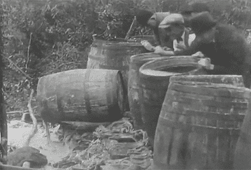 Men dump out barrels of alcohol into mud