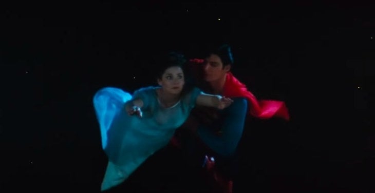 Superman and Lois fly through the night sky arm in arm