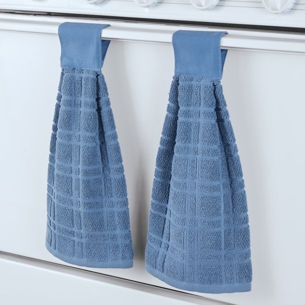 The towels in blue on an oven door handle