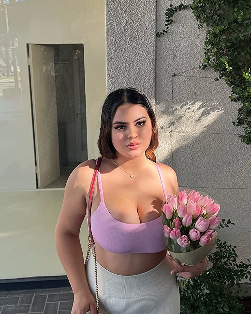 reviewer in the white shorts with sports bra and holding bouquet of tulips