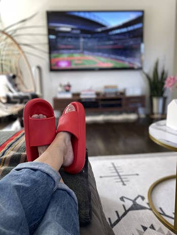 reviewer sitting with feet crossed wearing red slides