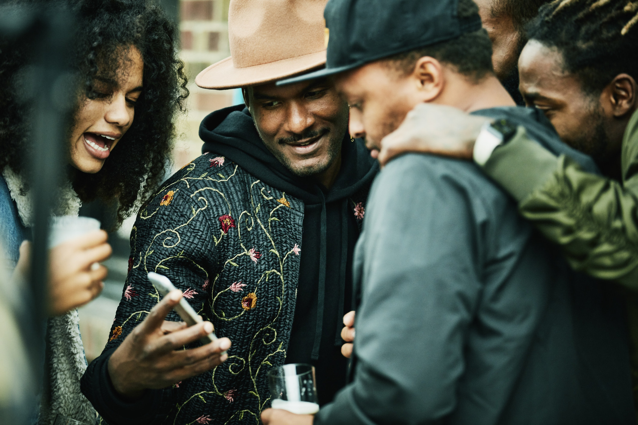 A group of friends gathered around one person&#x27;s phone