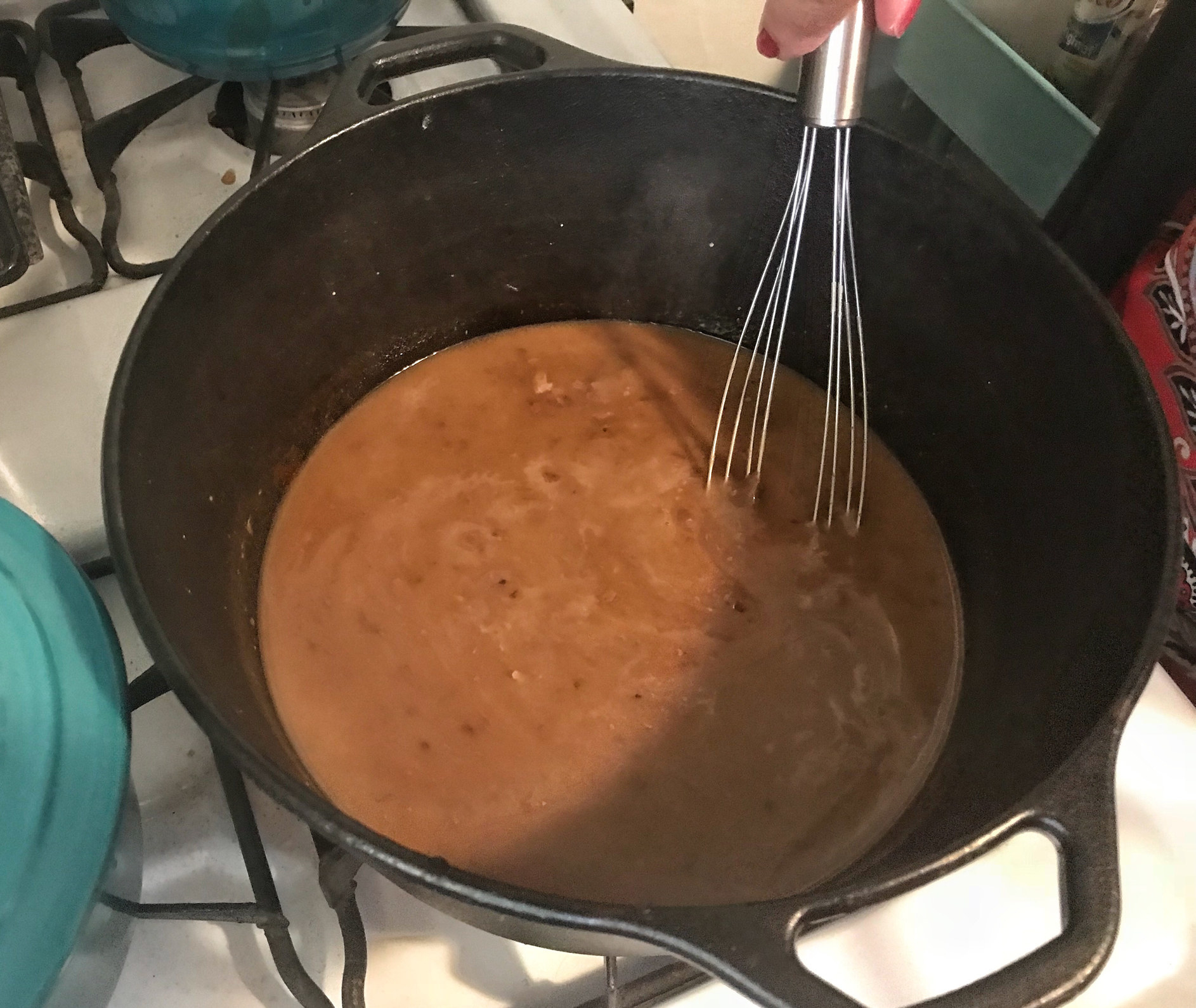 Whisking gravy in a pot.,