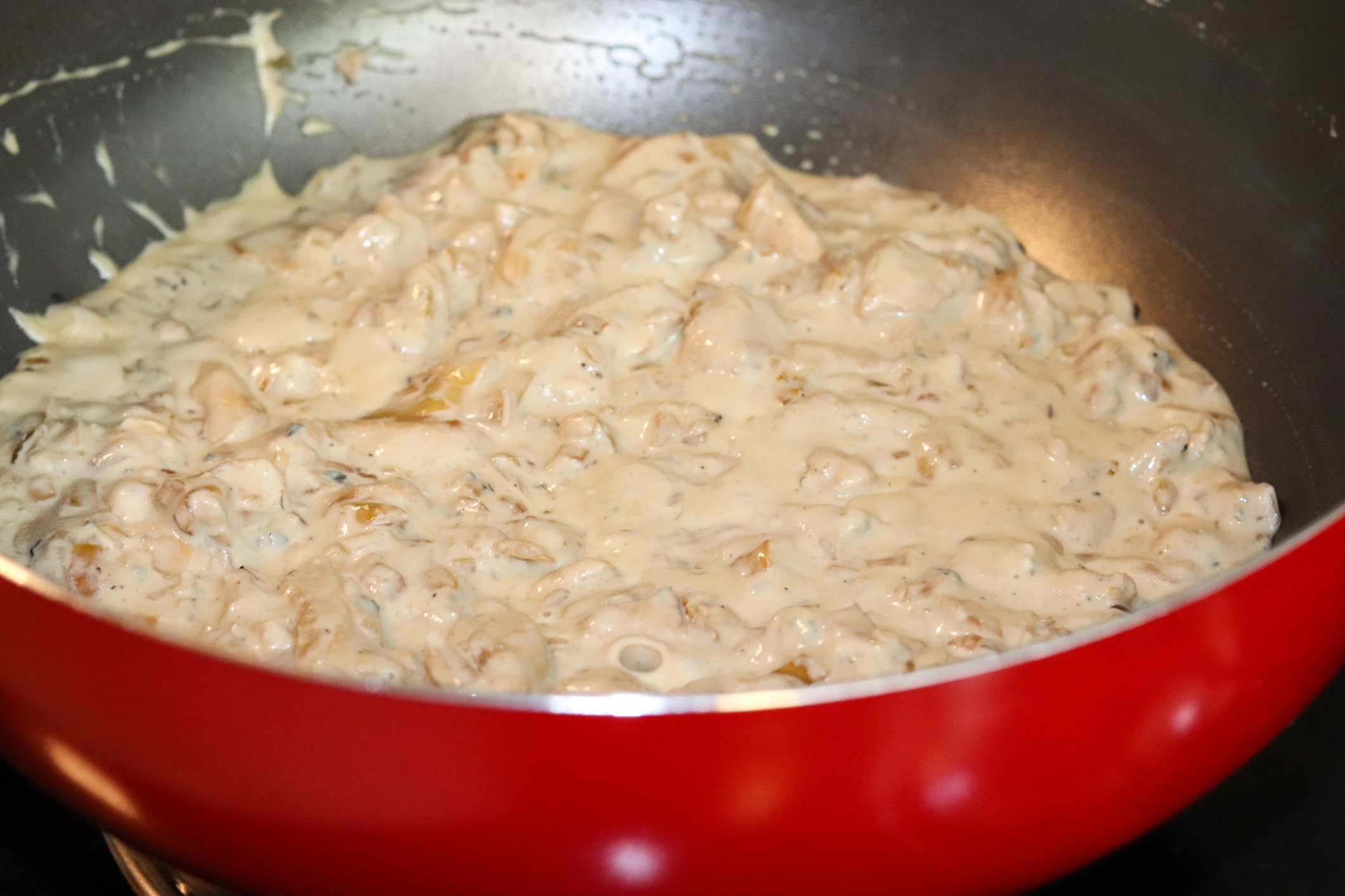 A pot of chicken and cheese sauce.