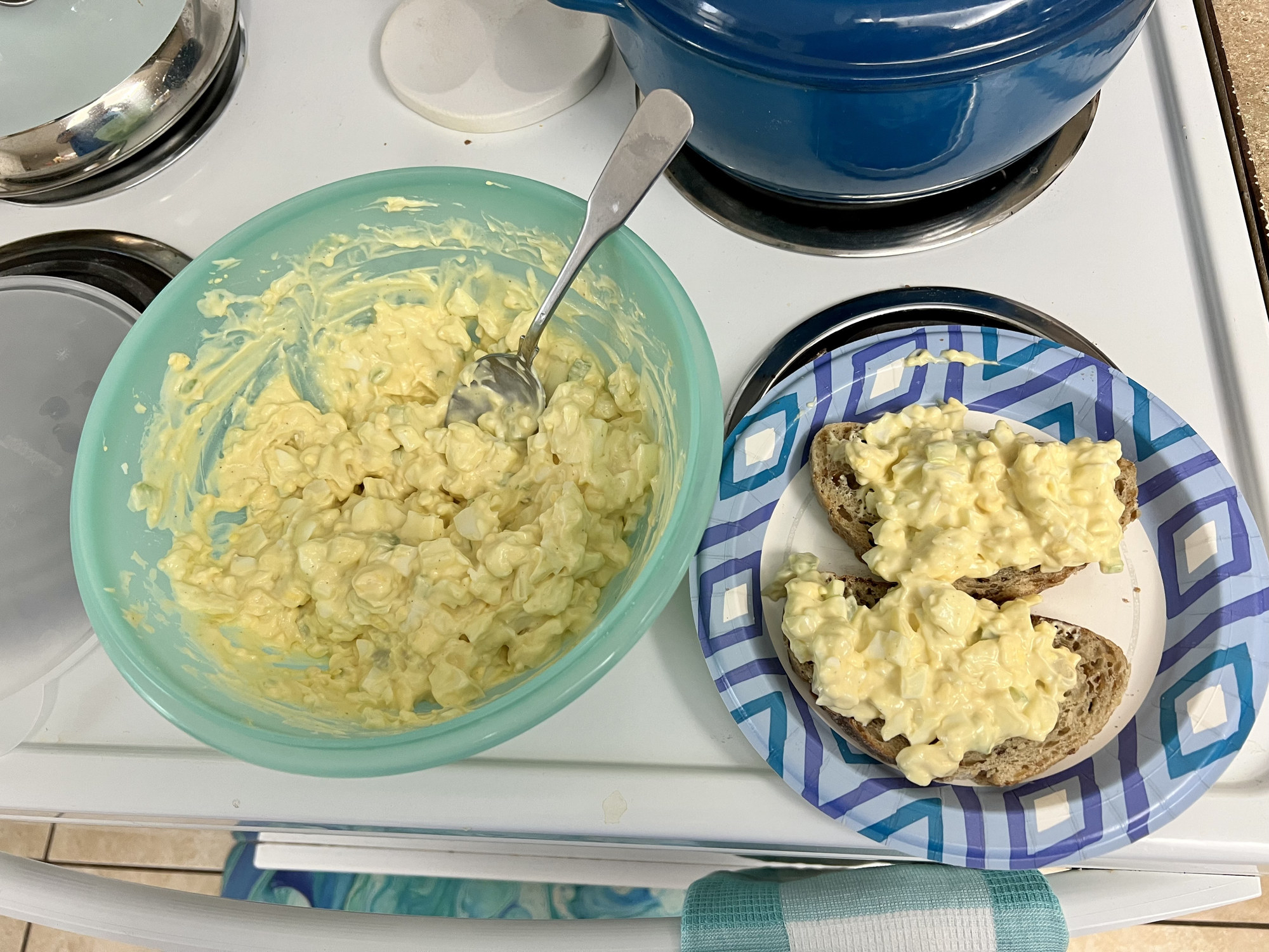 Homemade egg salad sandwich on multigrain bread on the stovetop.