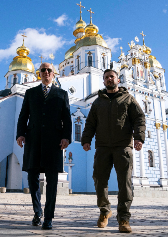 joe biden and volodymyr zelensky walk side by side in winter clothing in kyiv