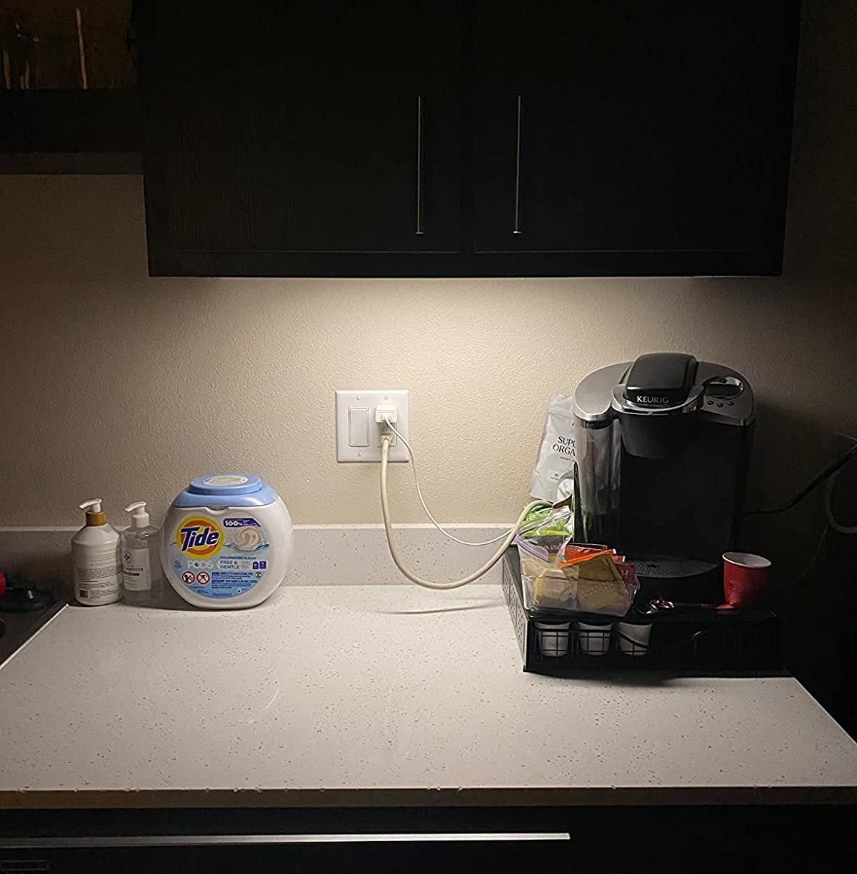 reviewer with light installed under kitchen cabinet and illuminating coffee maker on counter