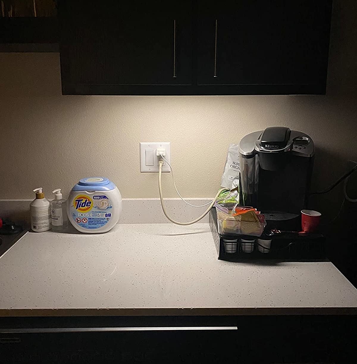 reviewer with light installed under kitchen cabinet and illuminating coffee maker on counter
