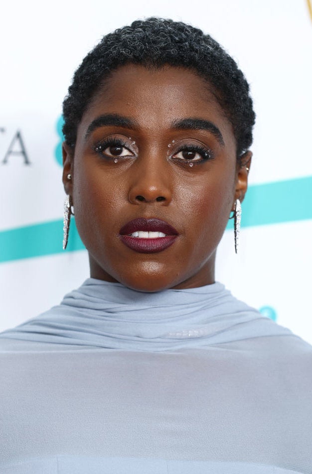 A closeup on Lashana Lynch showing off the crystals placed carefully around her eyes