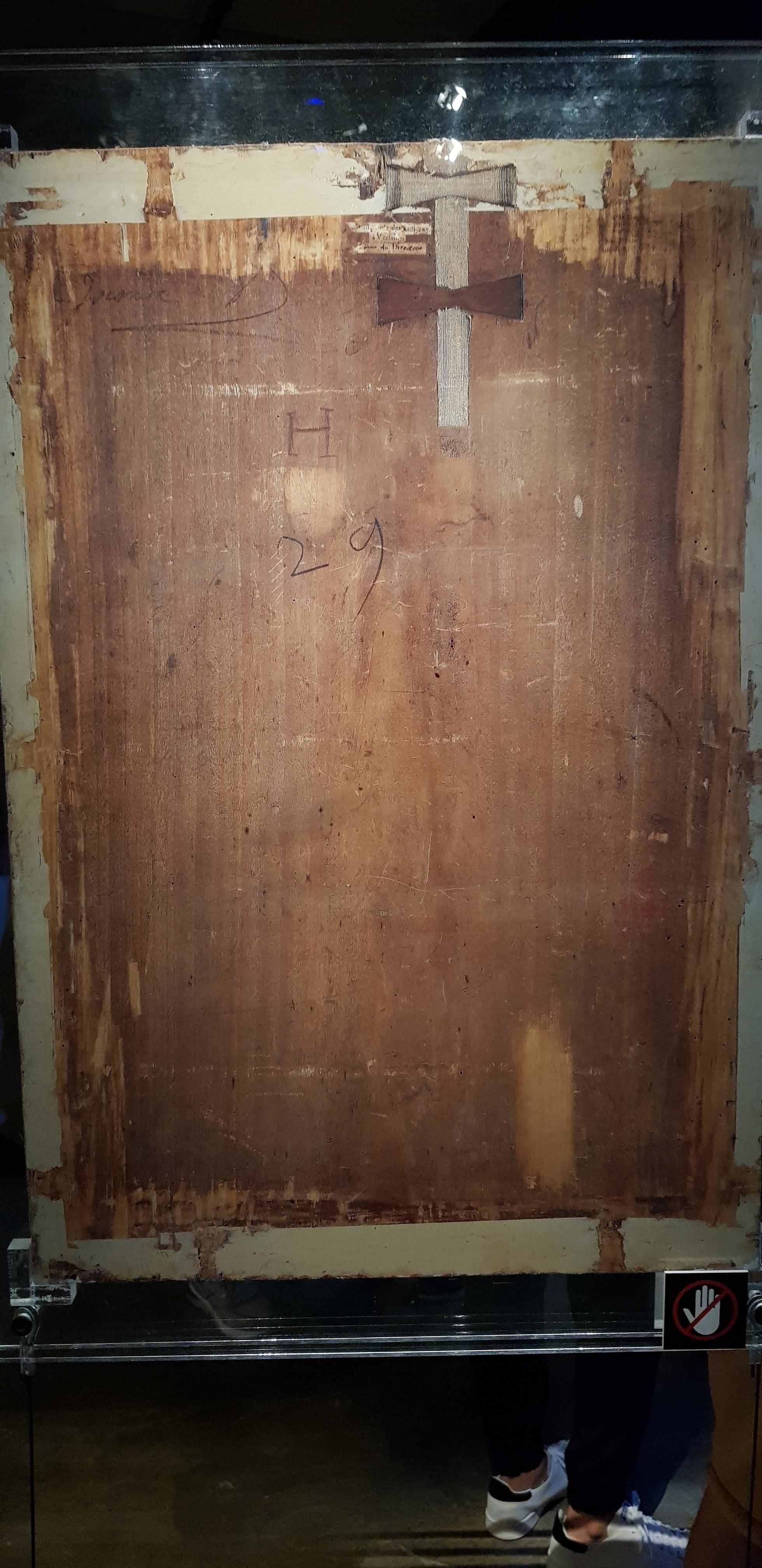 A nondescript back of a wooden canvas with &quot;H&quot; and &quot;29&quot; written on it