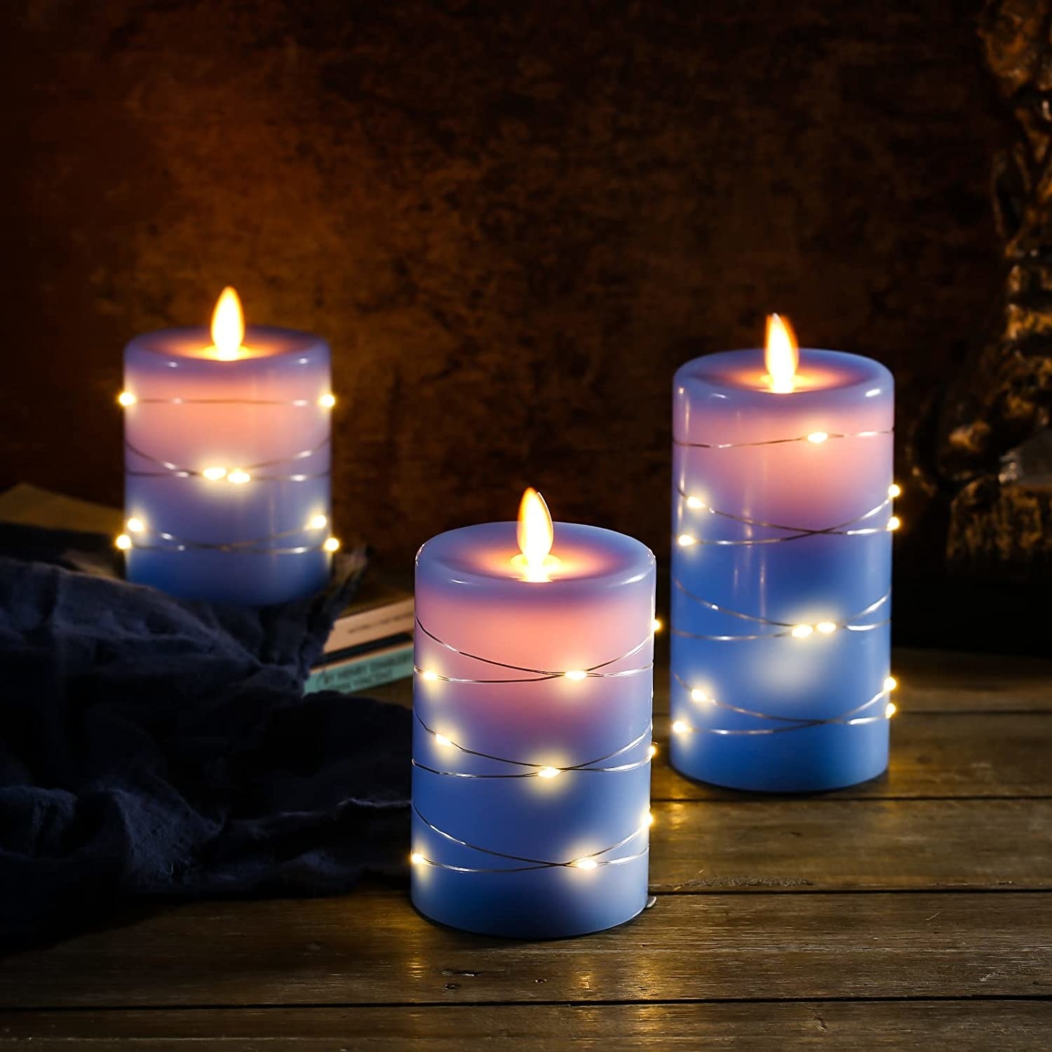 a trio of flameless candles with fairy lights wrapped around them