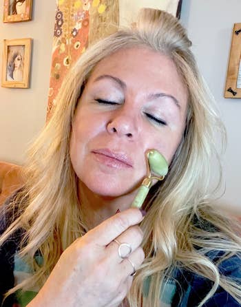 a reviewer rolling the jade roller on their skin
