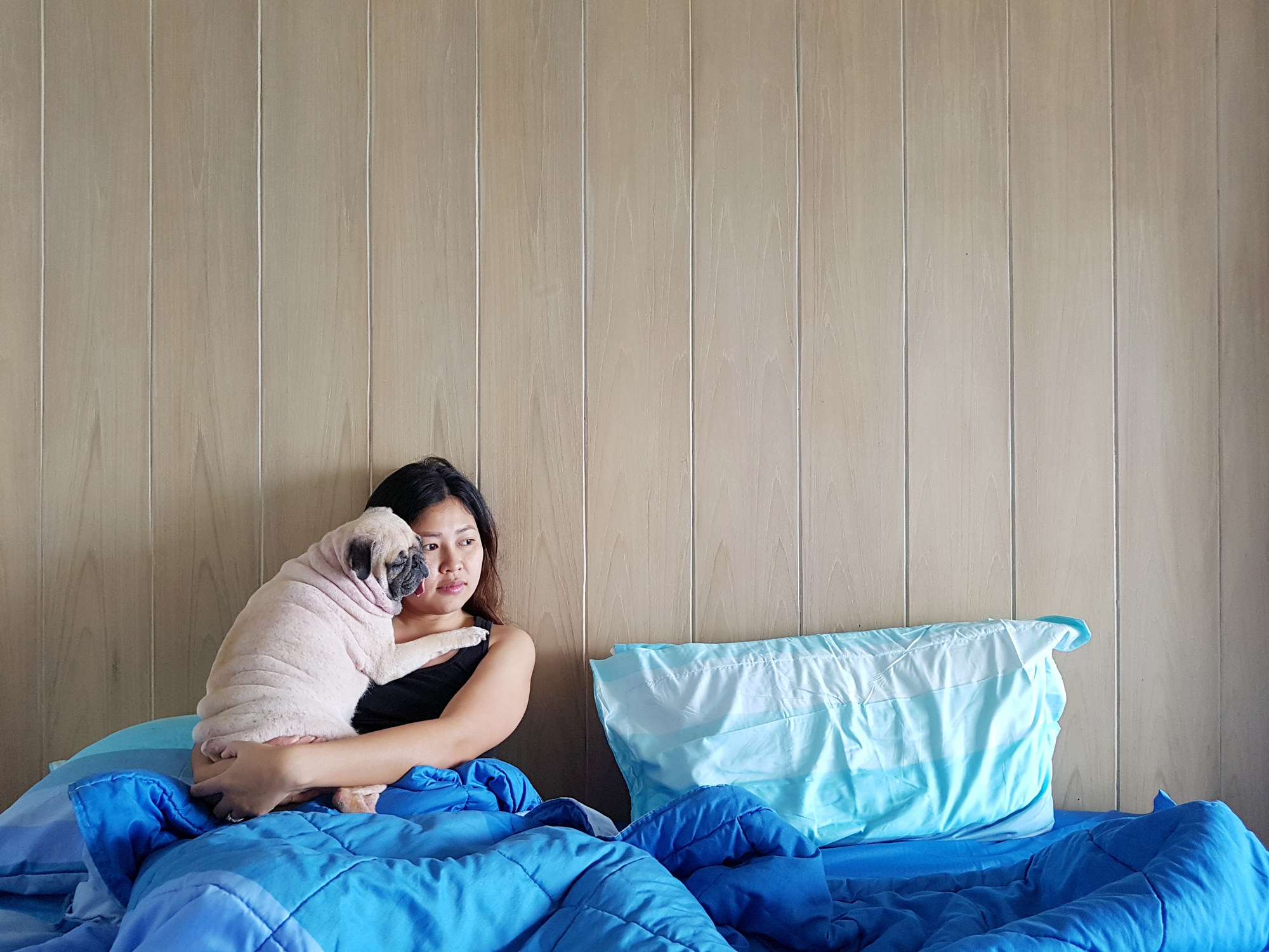 A woman in bed with her dog