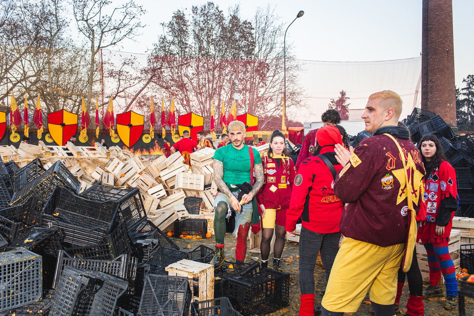 People, messy with debris after the event, stand beside piles of different plastic and wooden crates