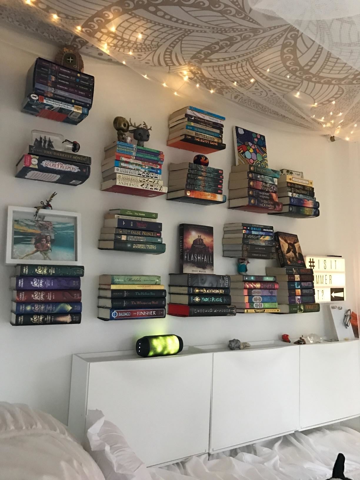 another reviewer photograph  of their partition  with respective  floating bookshelves holding respective  stacks of books