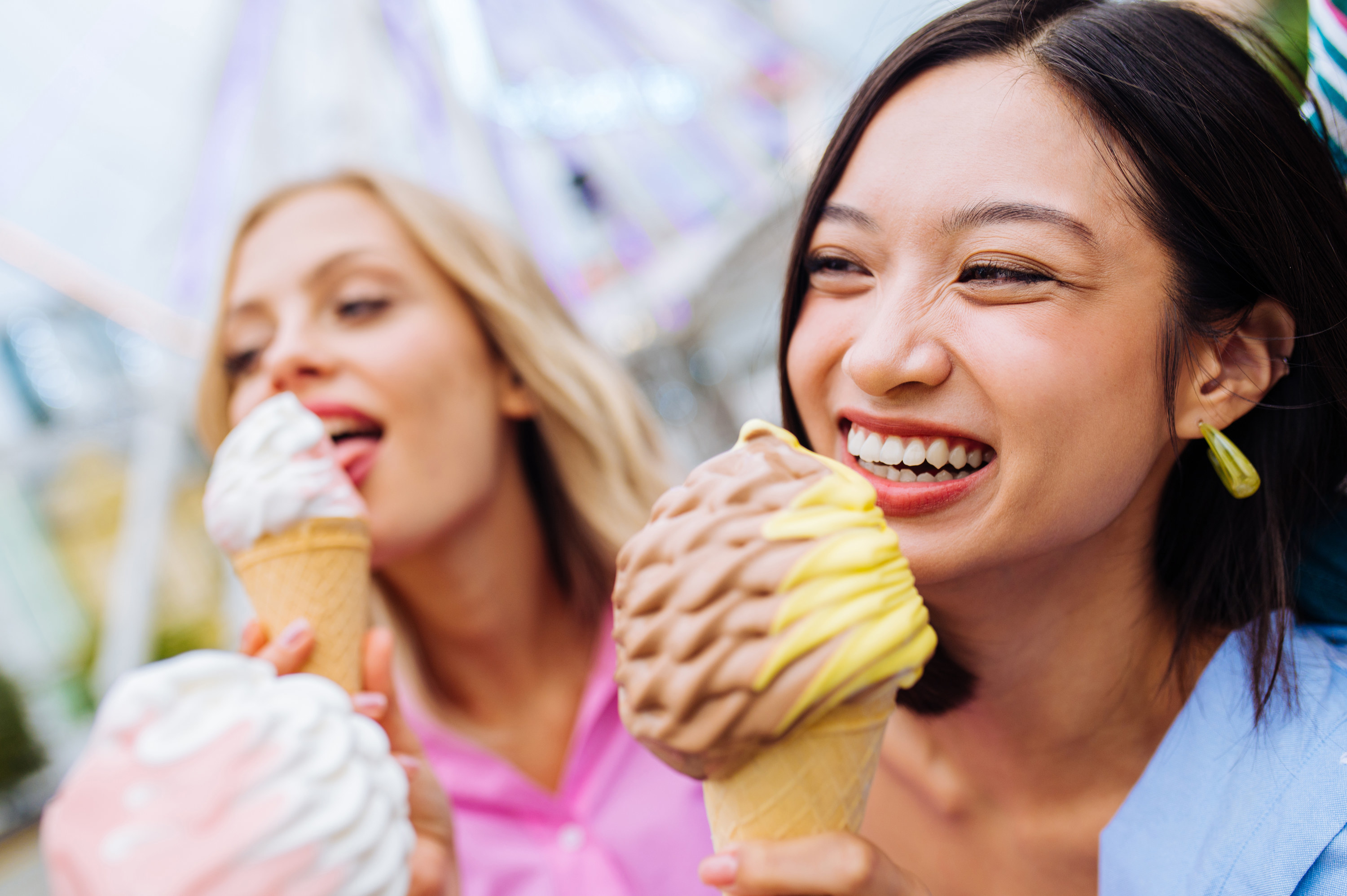 An image of two friends enjoying brightly coloured whipped ice creams
